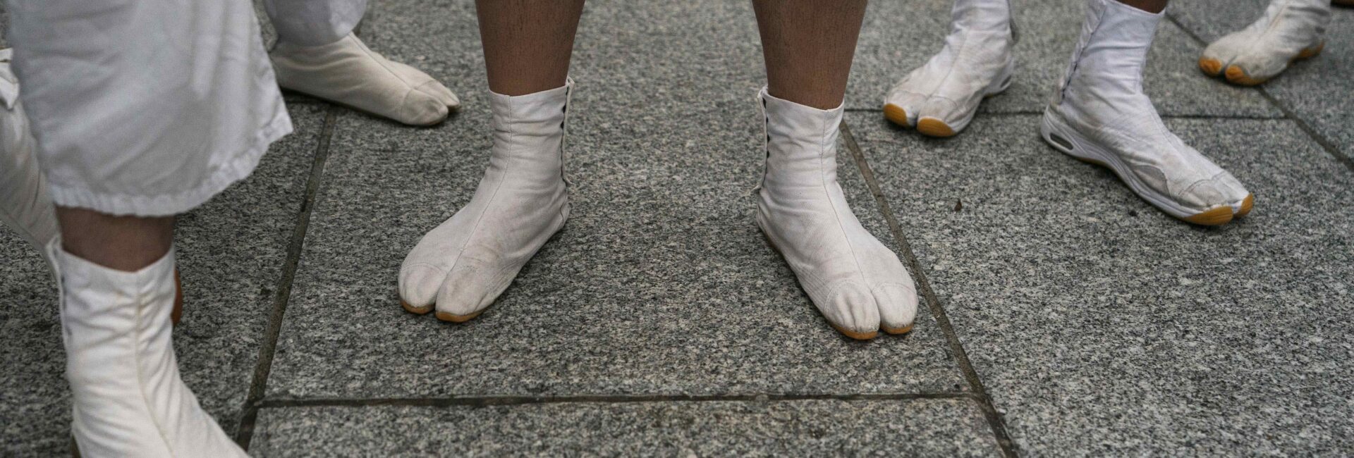 People wearing tabi shoes wait for the start of a parade during the Mitama Matsuri at Yasukuni Shrine Saturday, July 13, 2019, in Tokyo. The four-day summer festival is held annually to comfort the souls of the war dead. (AP Photo/Jae C. Hong)